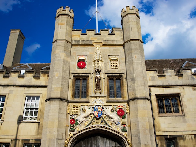 Ornate Gothic-style university entrance with intricate carvings and a royal emblem in the UK